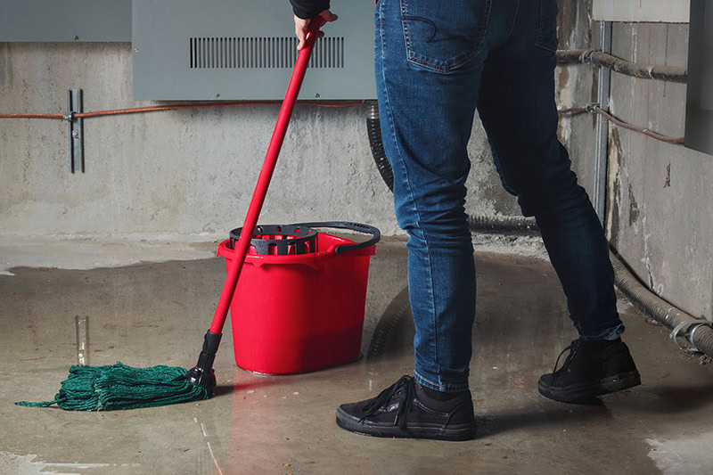 Man mopping up water on a floor.